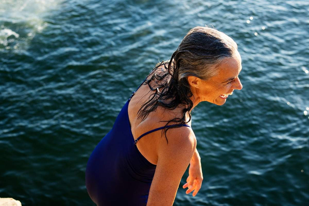 Woman smiling by the water on a sunny day