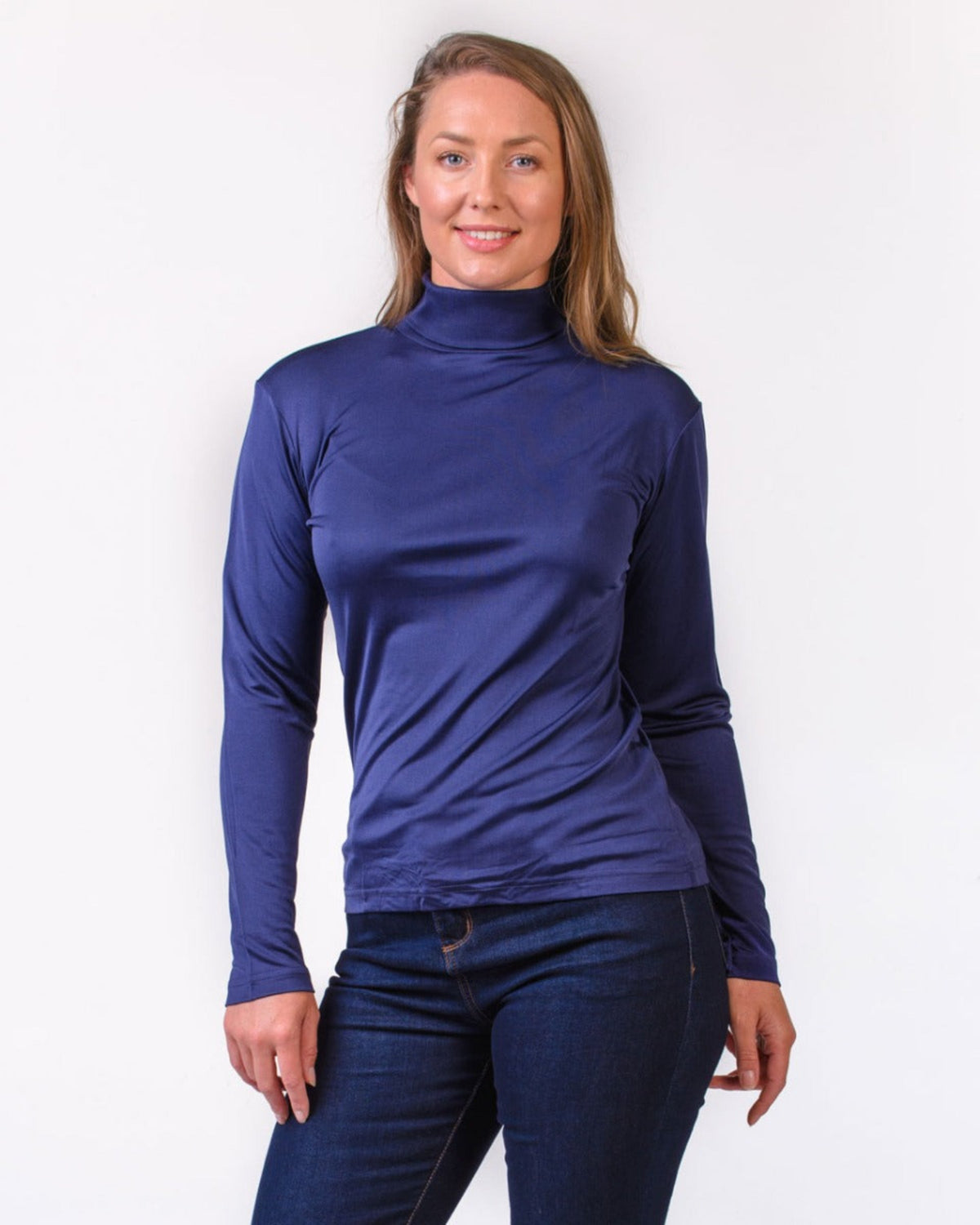 Woman wearing a silk blue long-sleeve turtle neck top against a white background