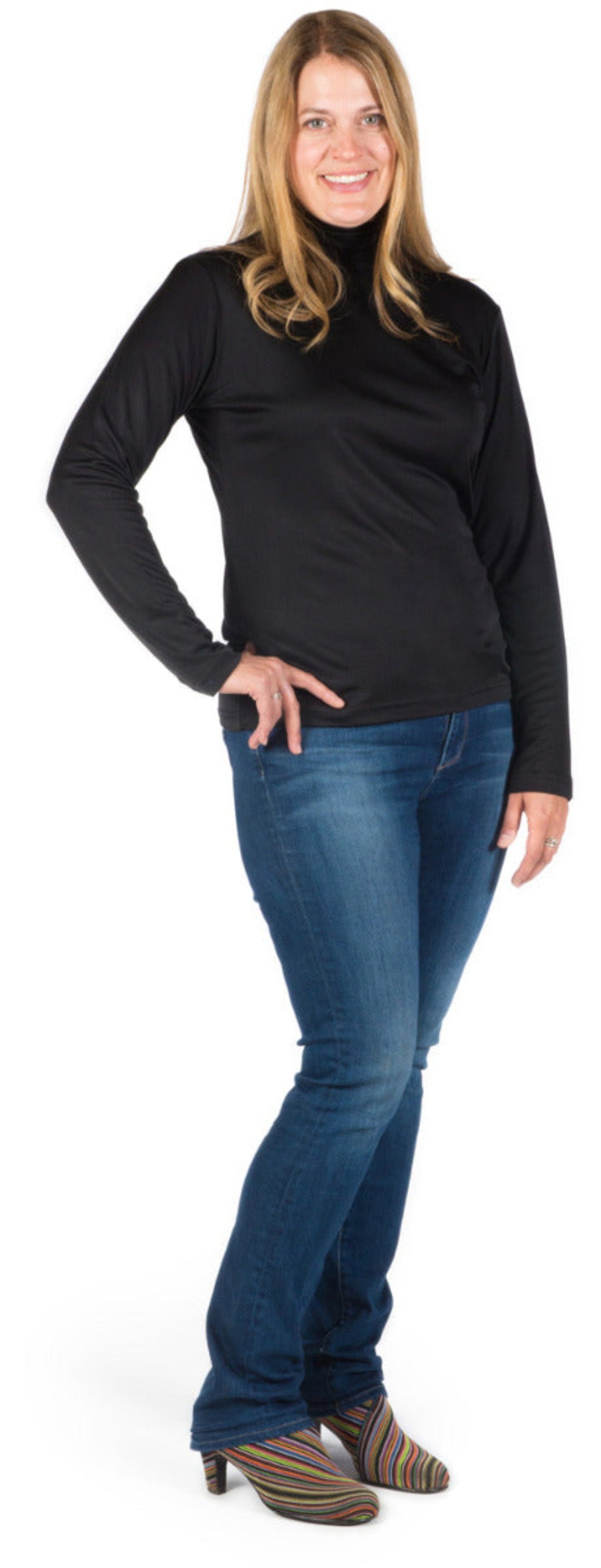 Woman wearing a silk  black turtleneck and blue jeans on a white background