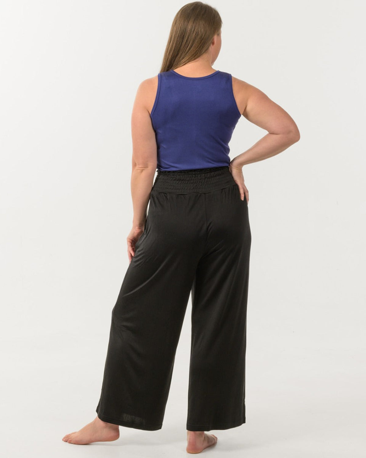 Woman wearing a silk blue top and silk black wide-leg pants 