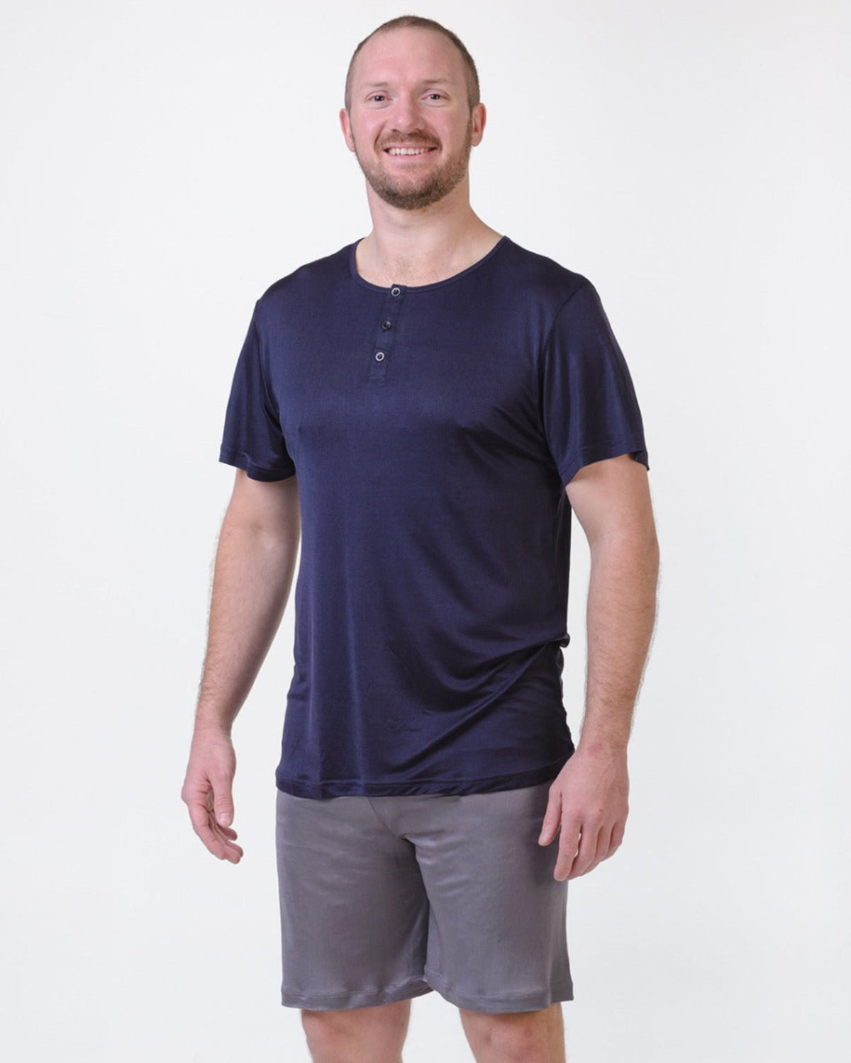 Man wearing a navy midnight blue henley shirt and gray shorts