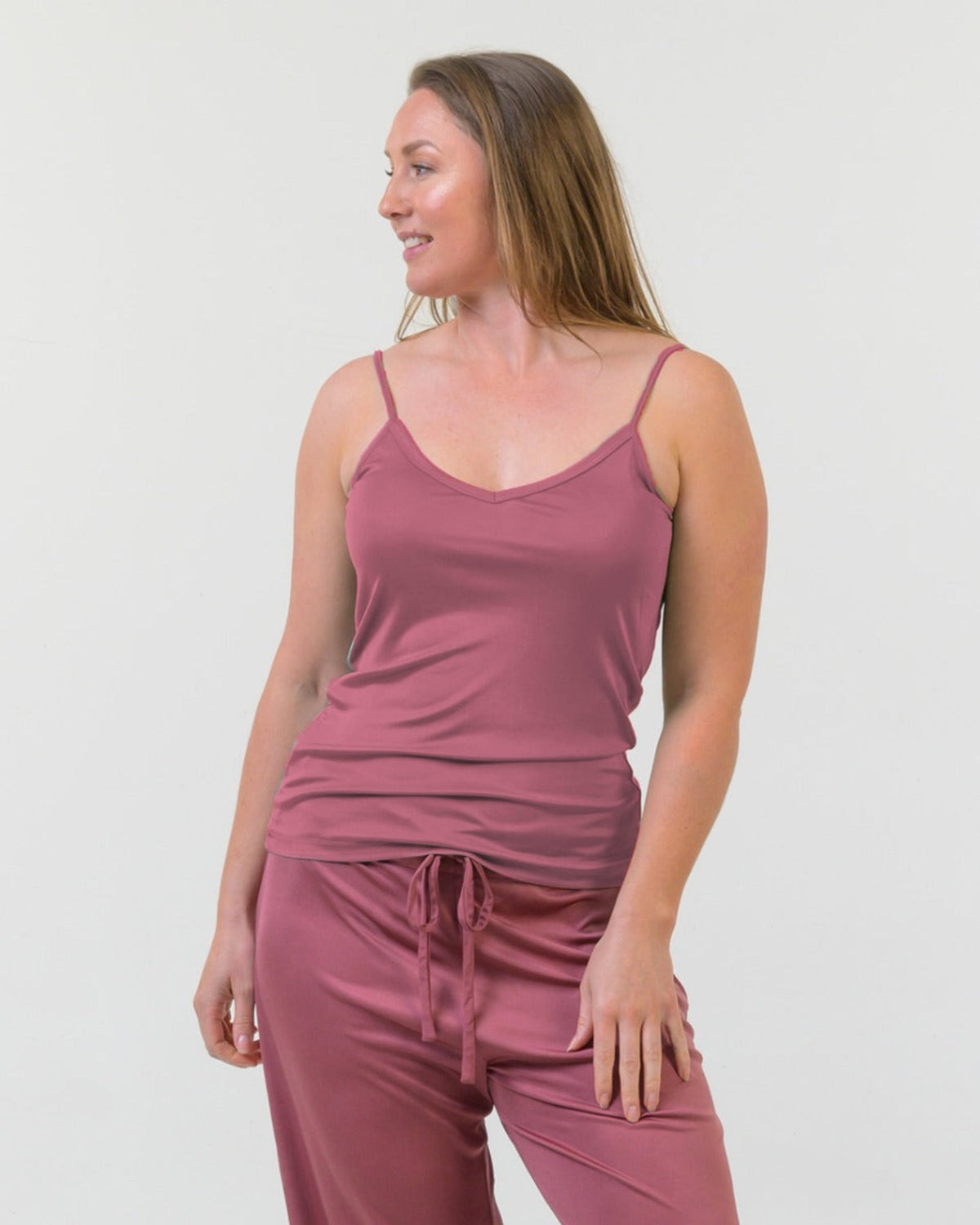 Woman wearing a silk  rose  camisole  top and pants