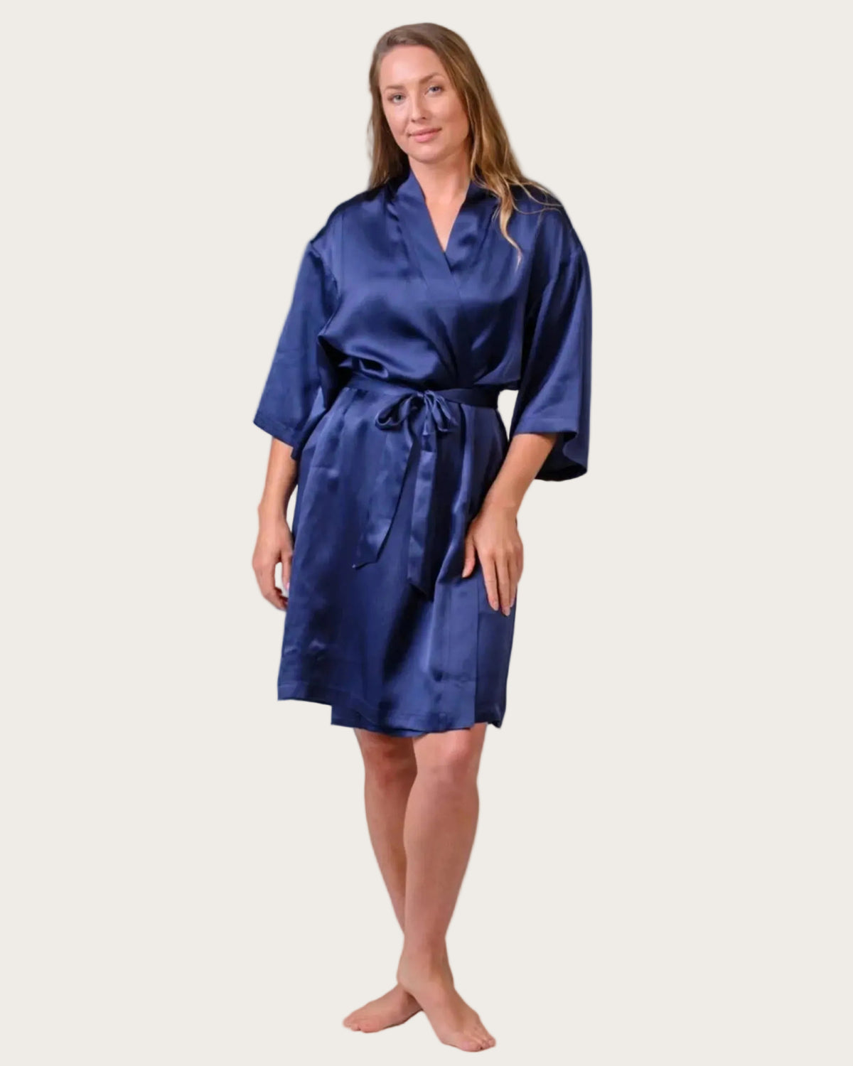 Woman wearing a silk blue satin robe on a white background