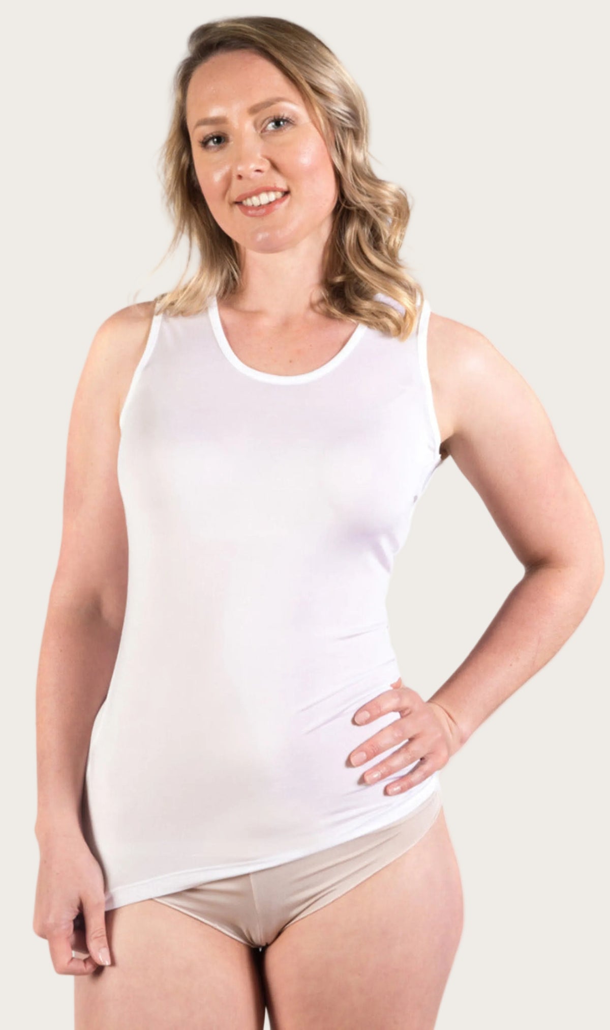 Woman wearing a white silk classic camisole and beige underwear 