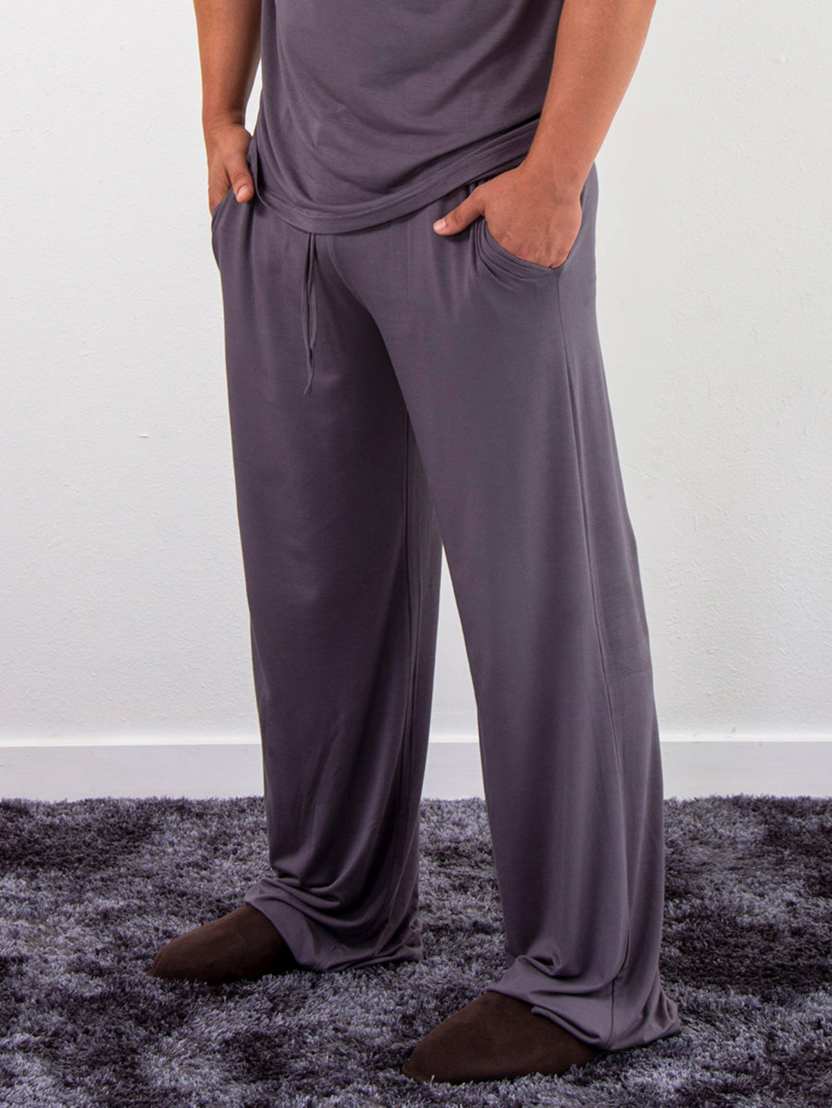 Person bamboo leisure wearing gray pajama pants standing on a textured surface with a white background