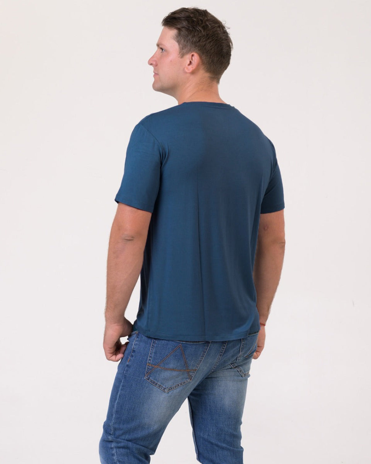 Bamboo v neck Man wearing a blue t-shirt and jeans on a white background
