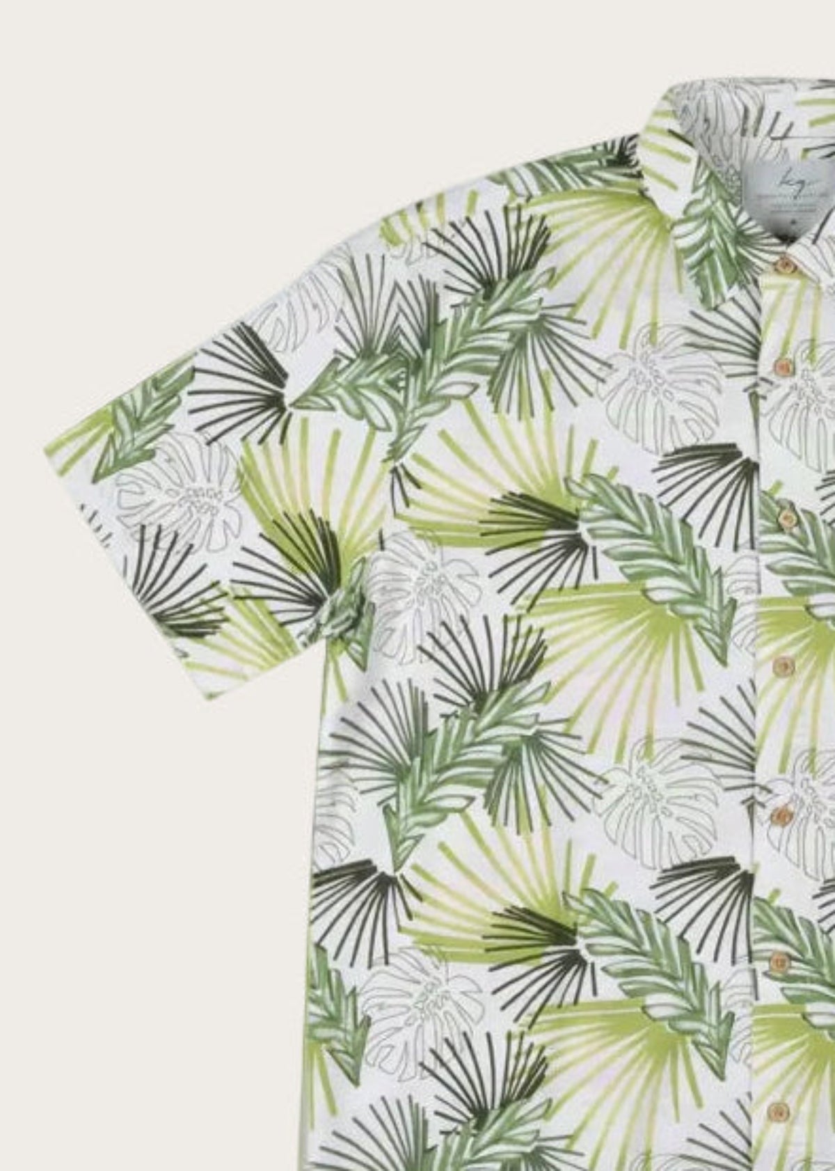 Short-sleeve shirt with green leaf pattern on a white background