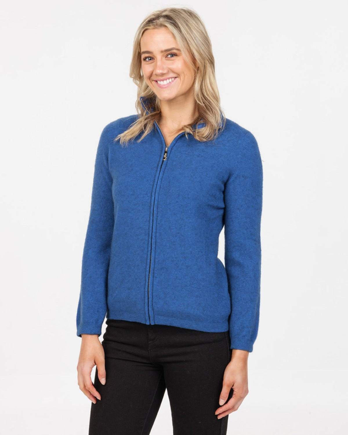 Woman wearing a pssum merino  blue zip-up sweater on a white background