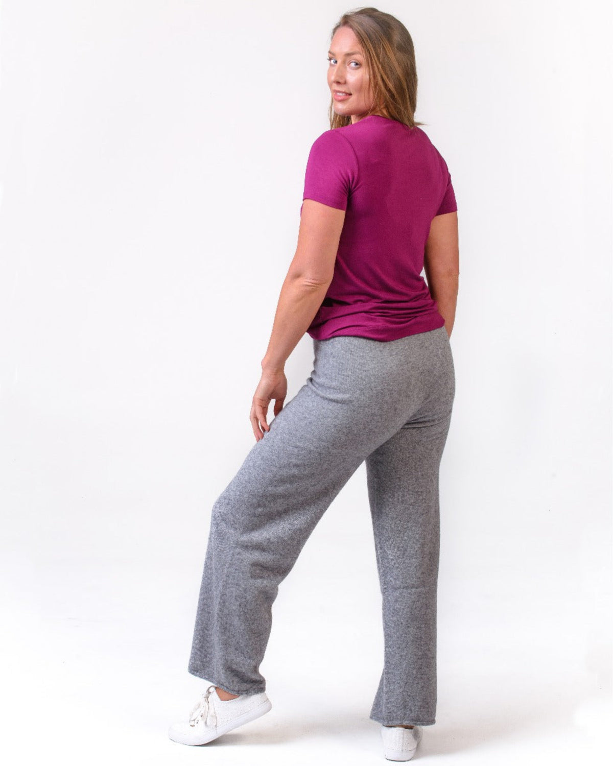 Possum merino Woman wearing a purple shirt and gray pants on a white background
