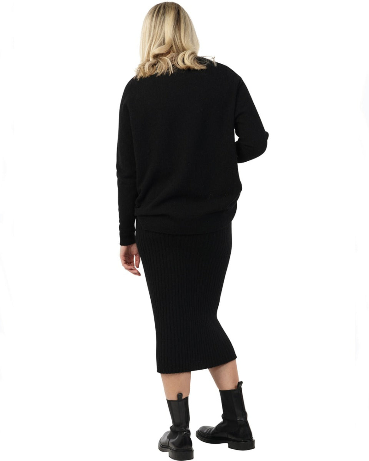 possum merino Person wearing a black sweater and skirt set on a white background