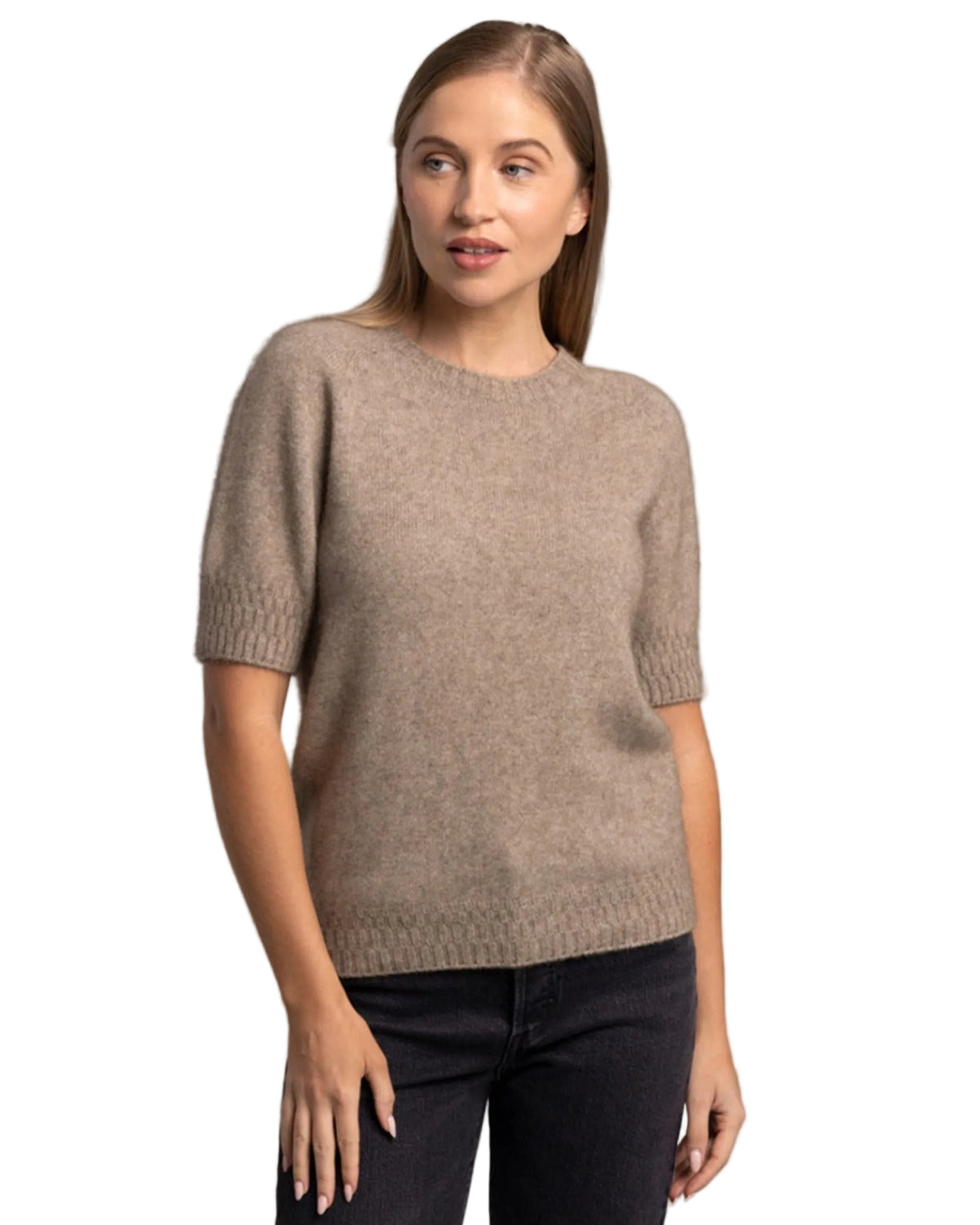 Possum Merino Woman wearing a beige sweater against a gray background