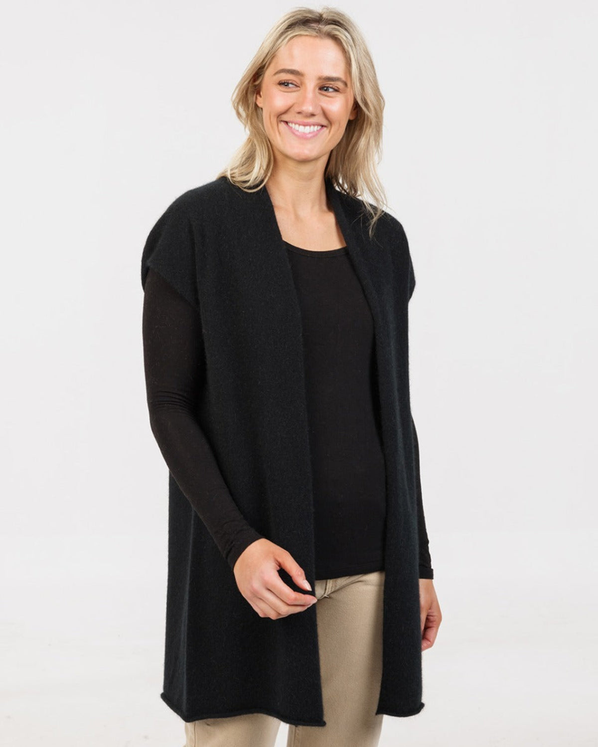 possum merino gilet Woman wearing a black cardigan over a black top on a white background