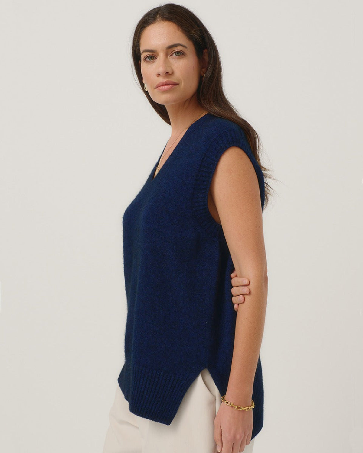 Possum merino Woman wearing a navy blue sleeveless sweater against a plain background