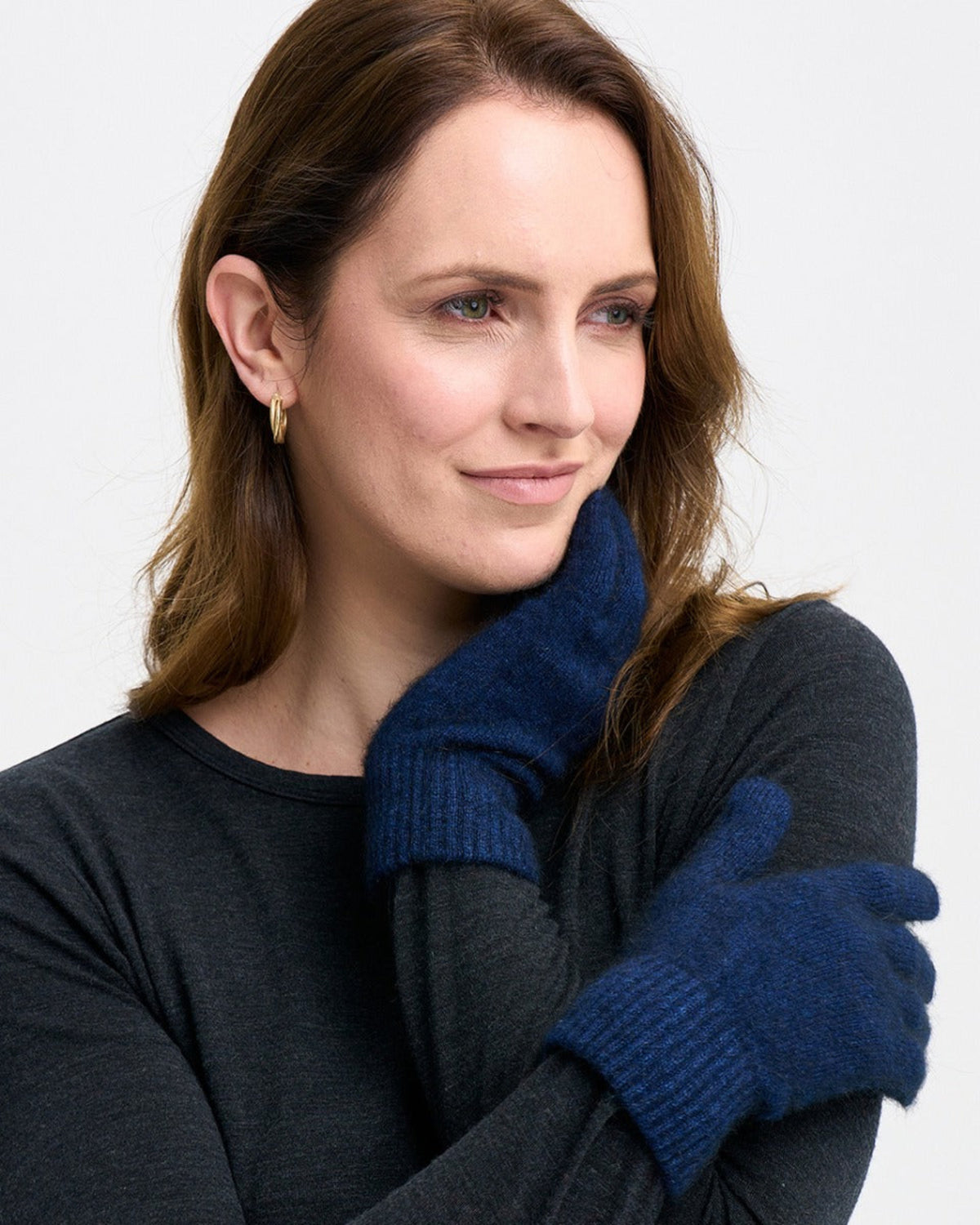 possum merino Woman wearing a dark gray sweater and blue gloves 