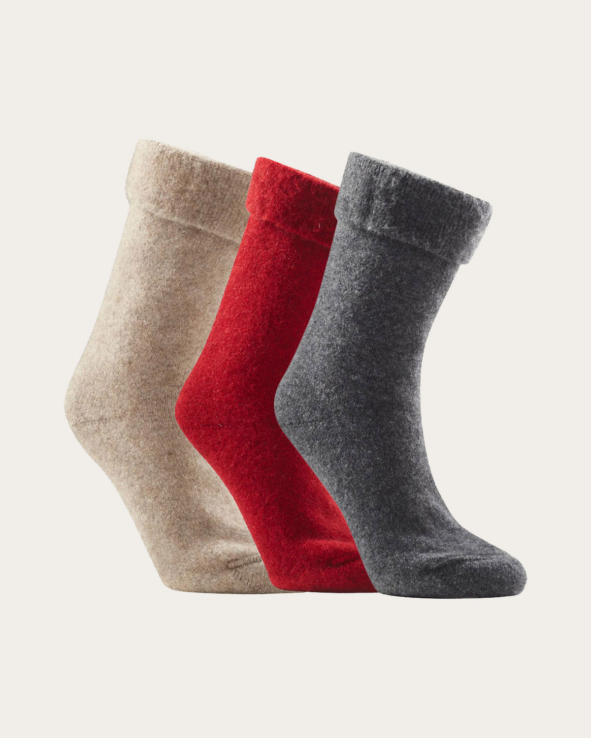 Three pairs of possum merino socks in beige, red, and dark gray, arranged in a fan shape against a light off-white background.