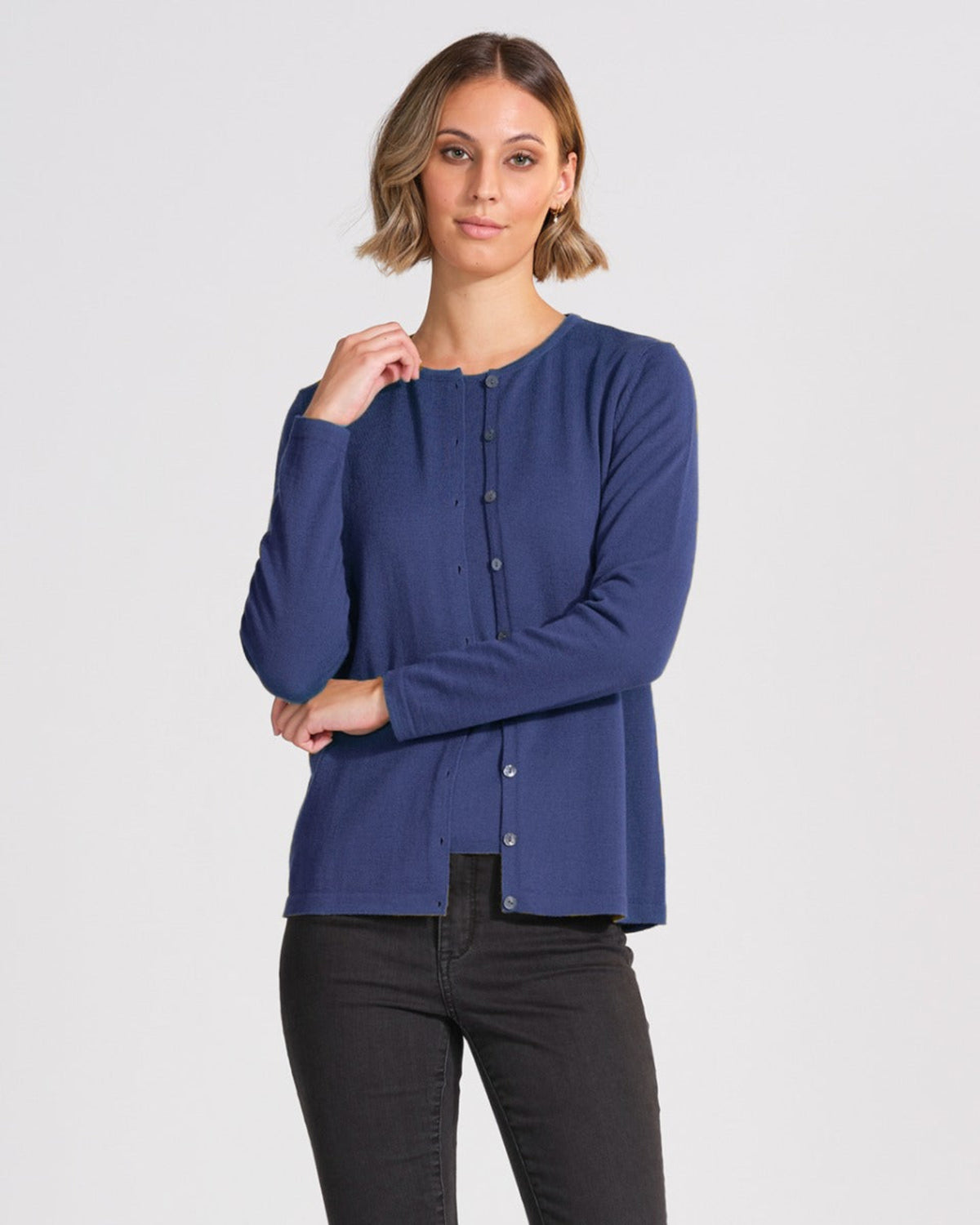 Woman wearing a merino blue long-sleeve shirt on a white background