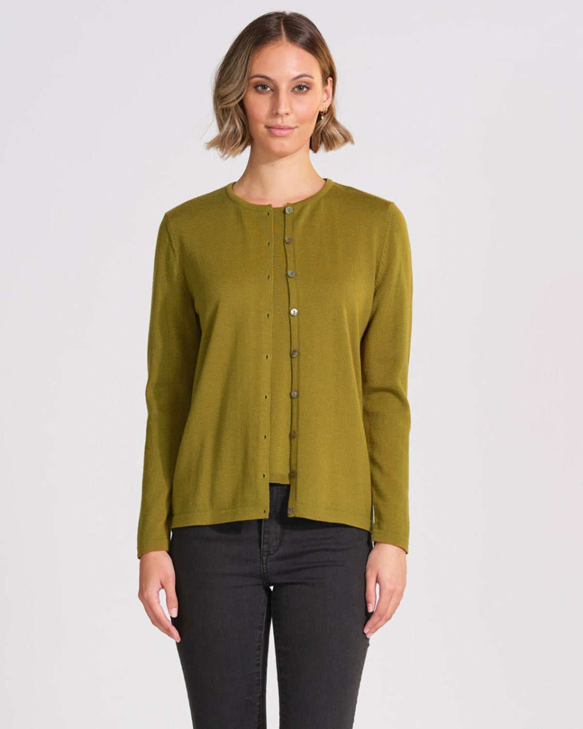 Woman wearing a merino green long-sleeve shirt on a white background