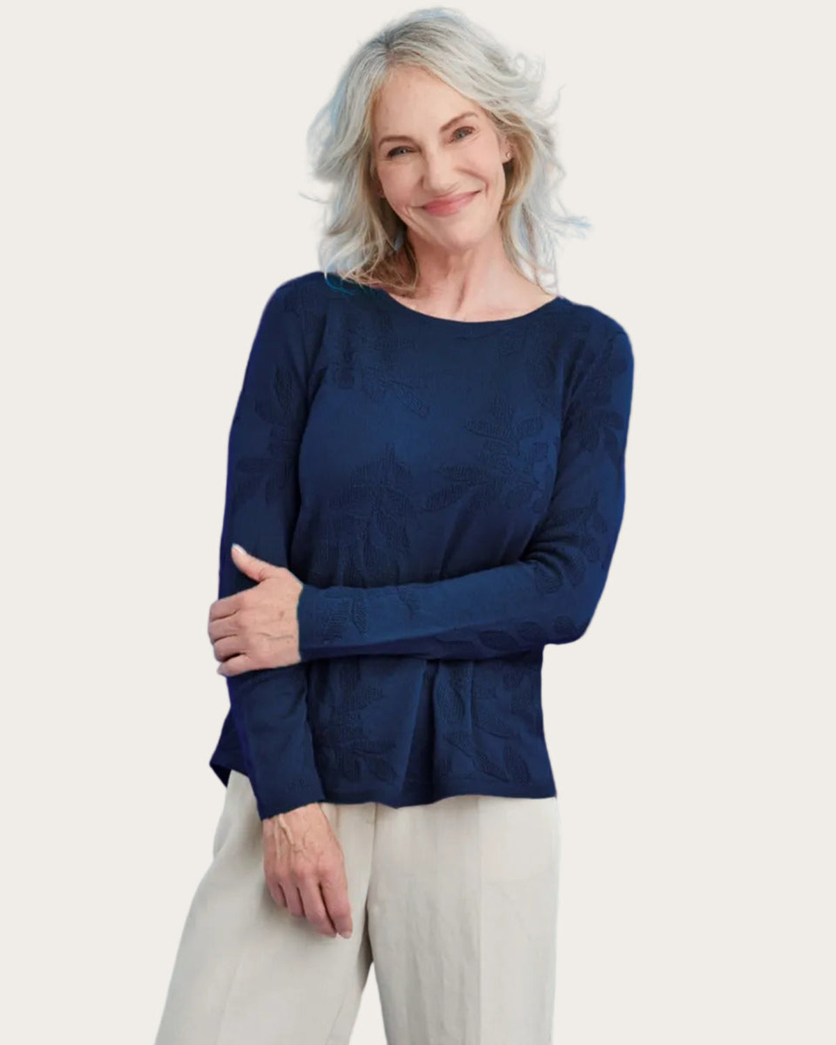 Woman wearing a merino navy blue top against a blue background