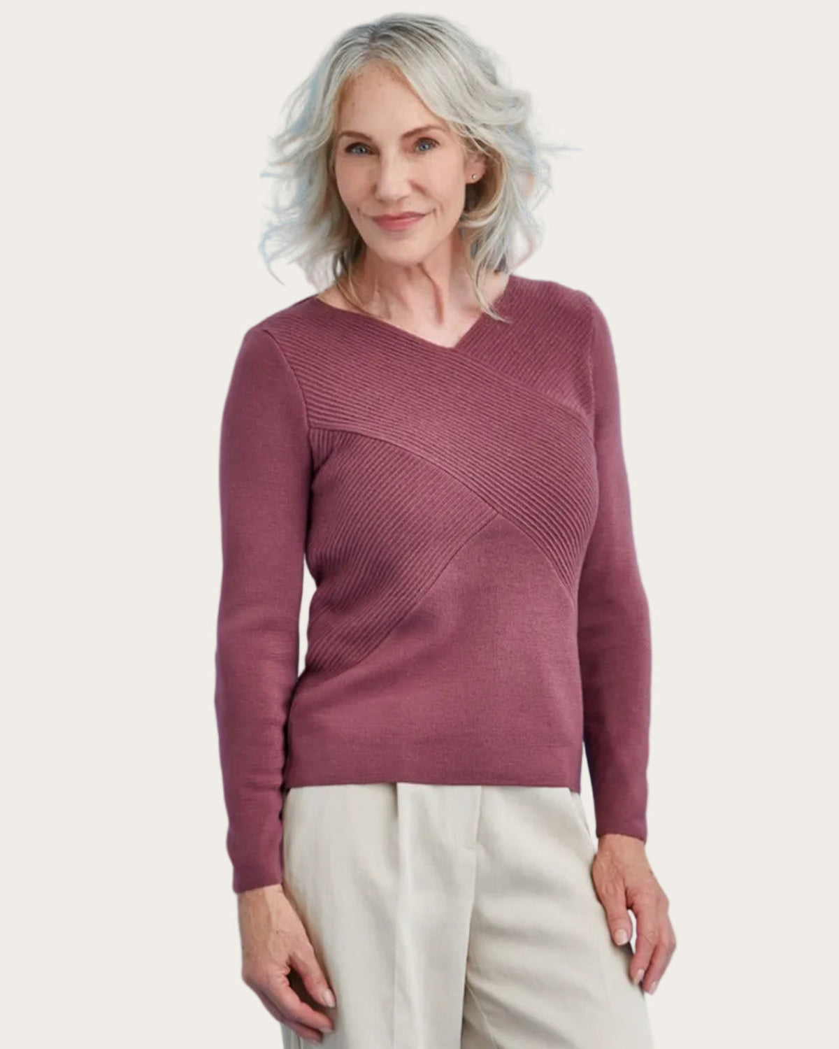 Woman wearing a merino maroon sweater against a blue background
