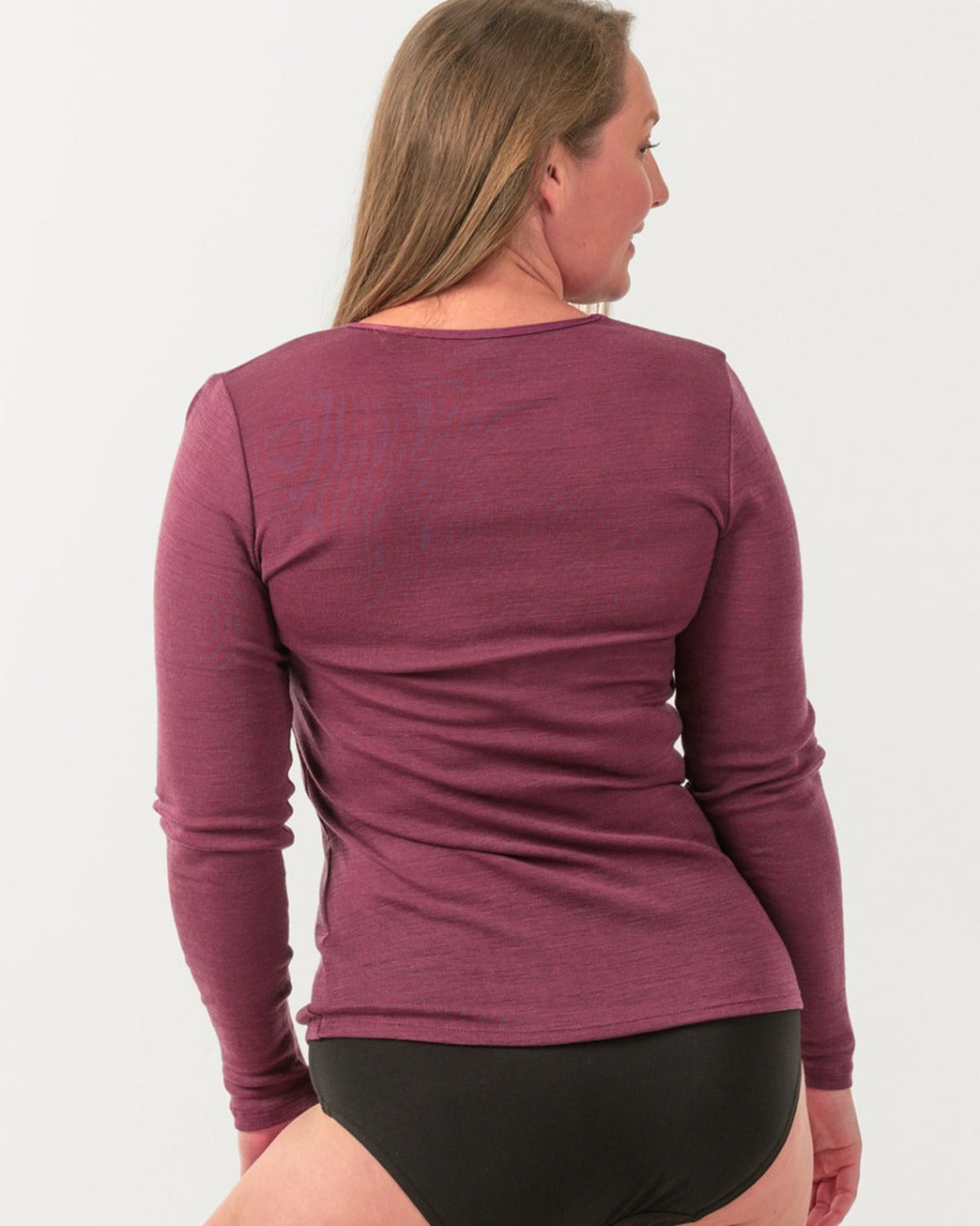 Person wearing a merino purple long-sleeve shirt on a white background