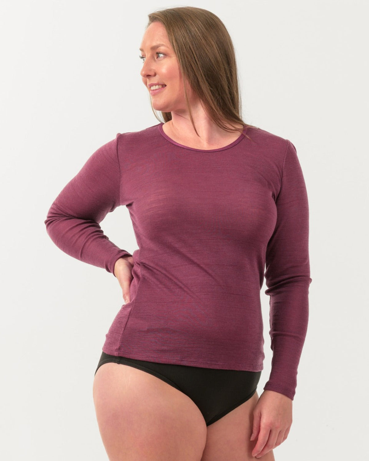 Woman wearing a merino purple long-sleeve shirt against a white background