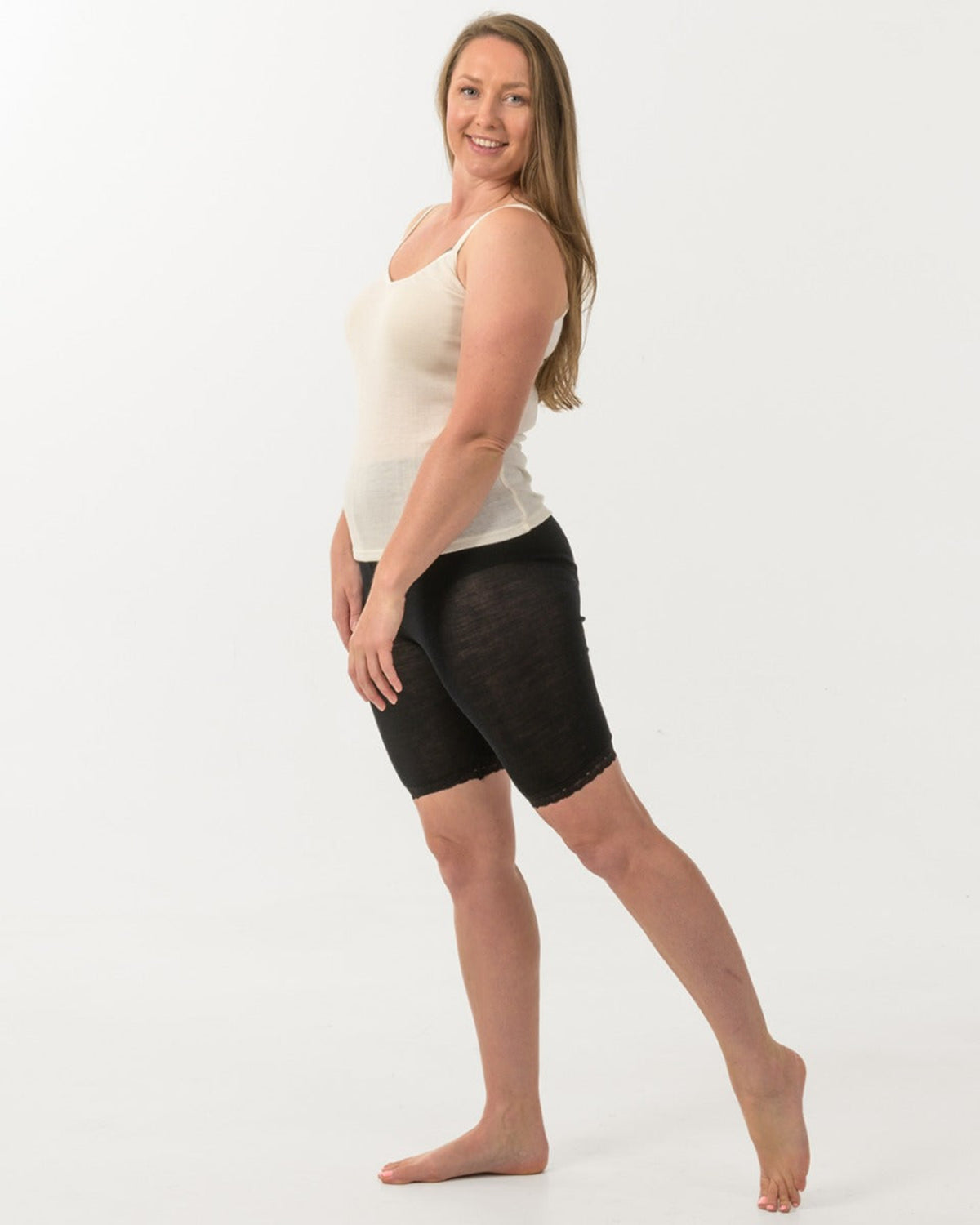 merino Woman wearing a white tank top and black shorts on a white background