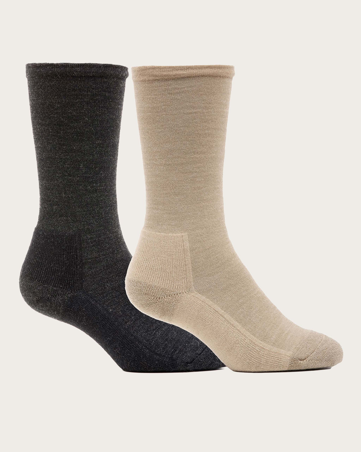 Two Merino wool crew socks shown on invisible forms against a light off-white background. One sock is dark charcoal gray and the other is light beige, with the beige sock positioned in front.