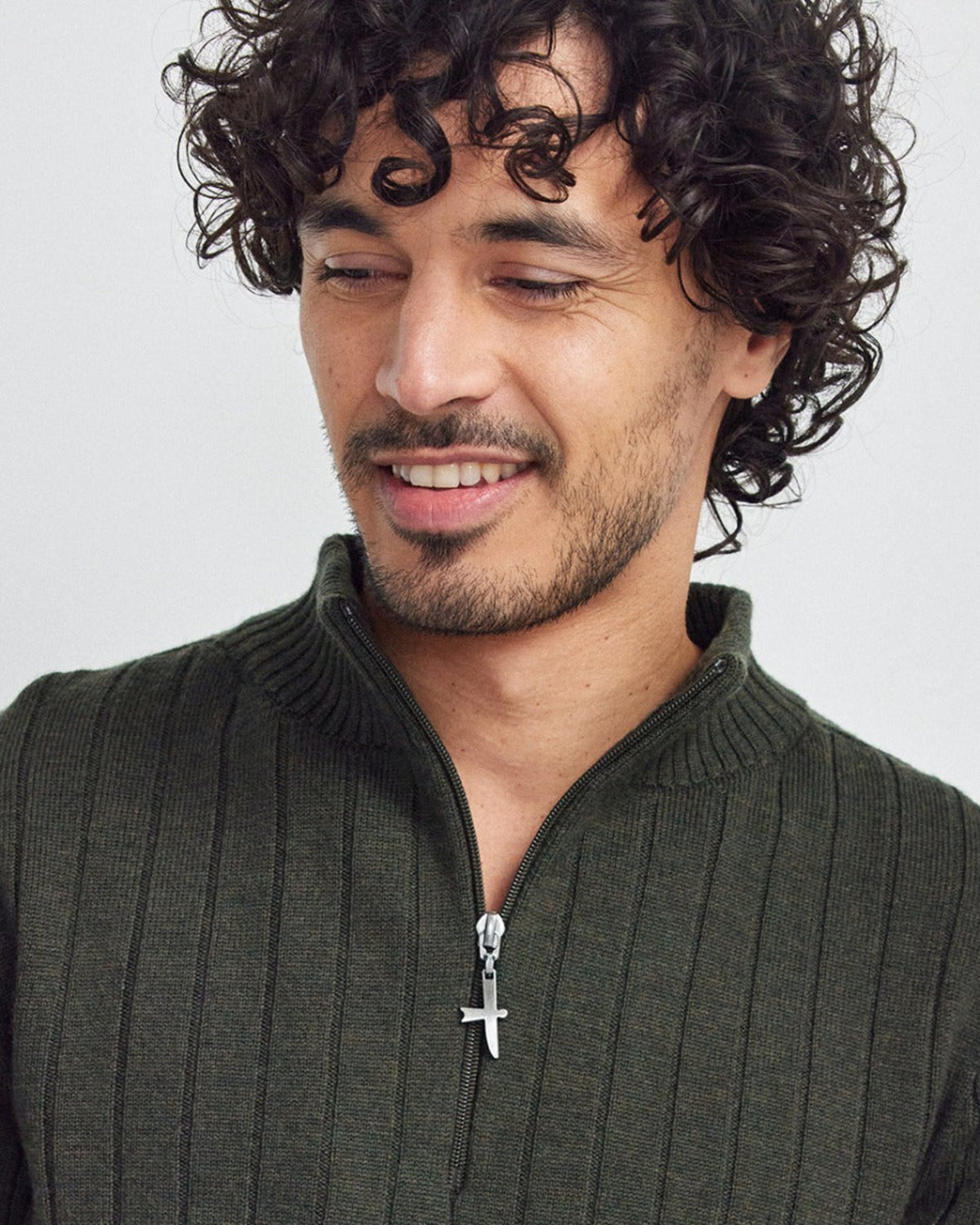 Man wearing a merino dark green sweater with a white background