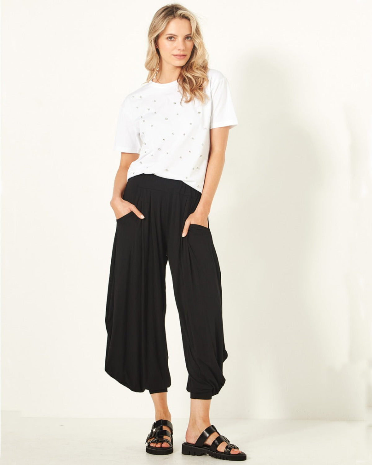 Viscoe Woman wearing a white t-shirt and black wide-leg pants on a white background