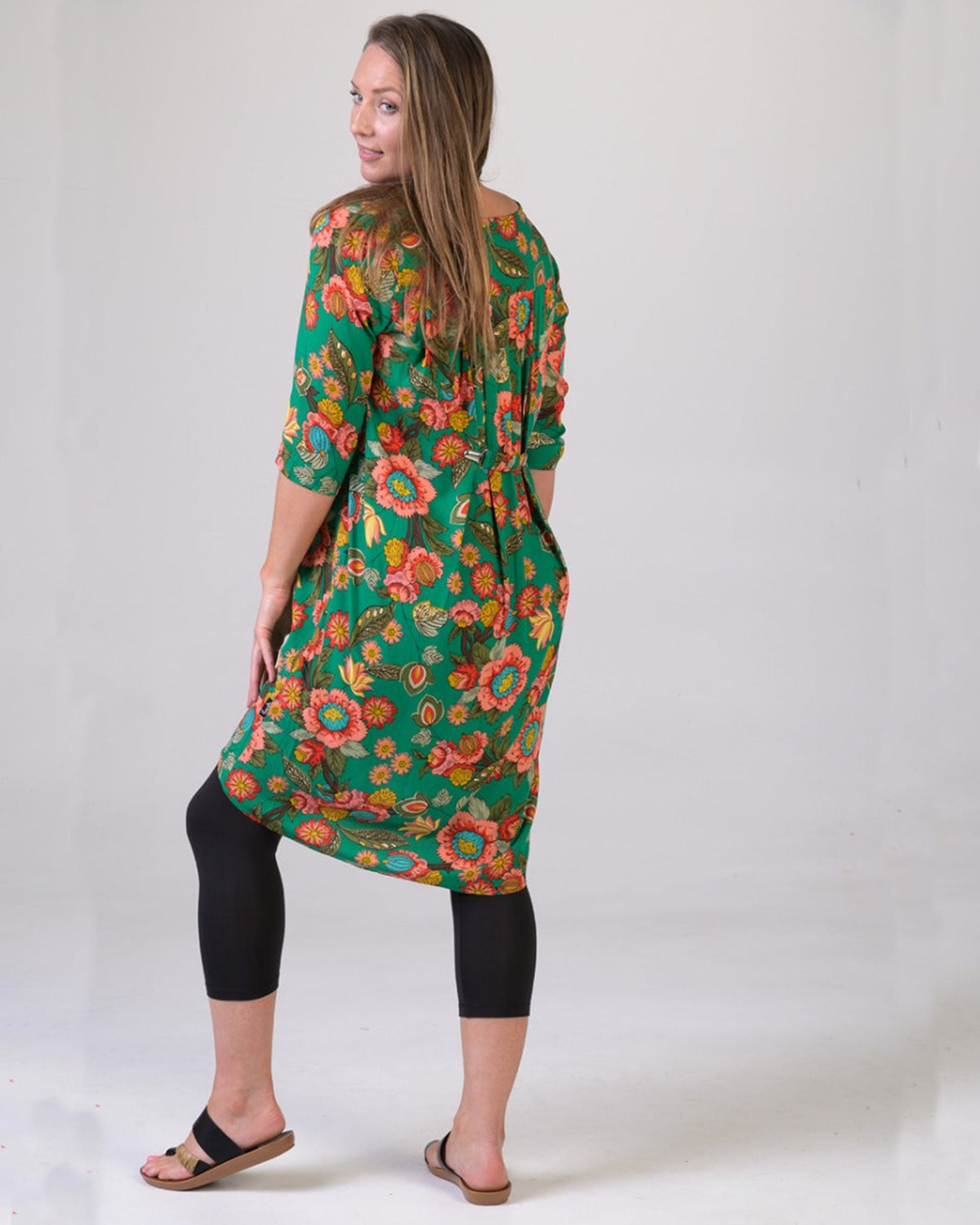 Woman wearing a green floral dress on a white background