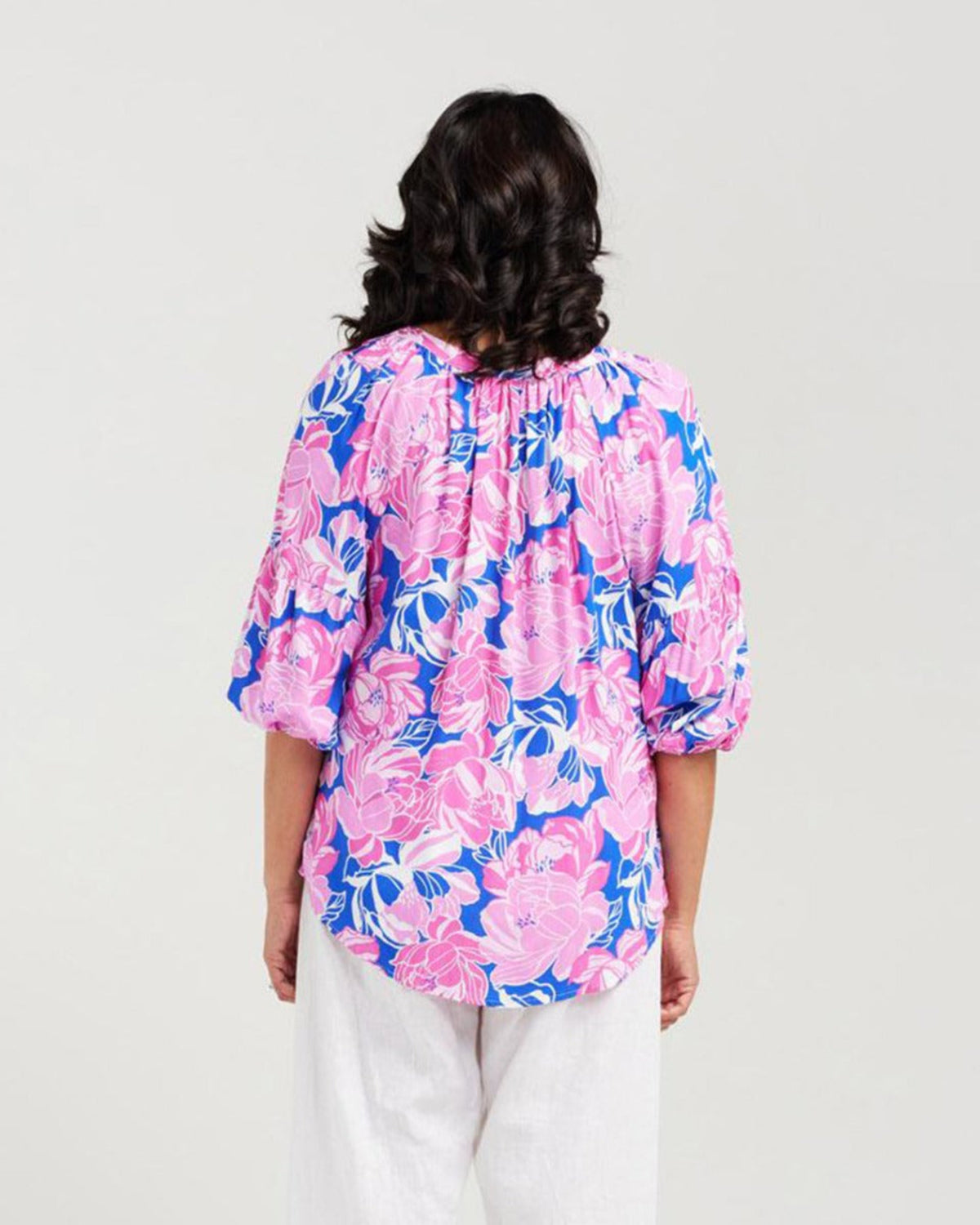 Woman wearing a pink floral blouse on a white background