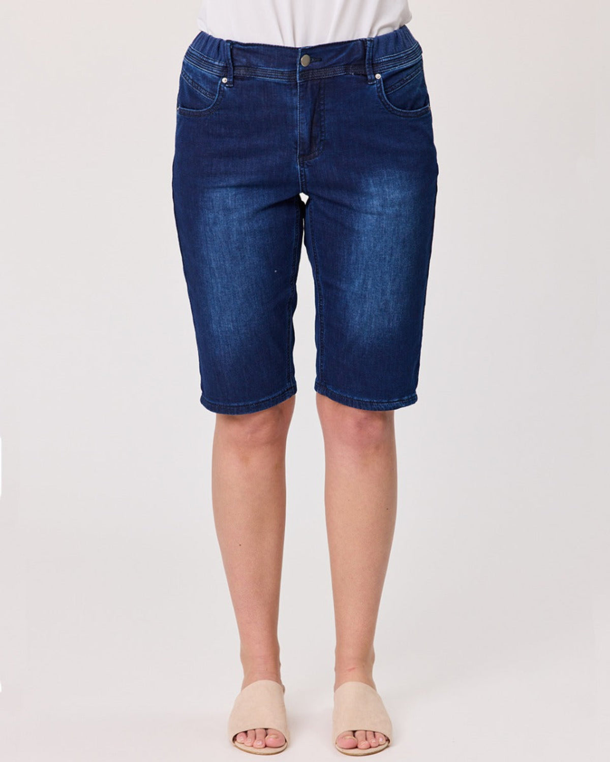 Blue denim shorts worn by a person on a white background