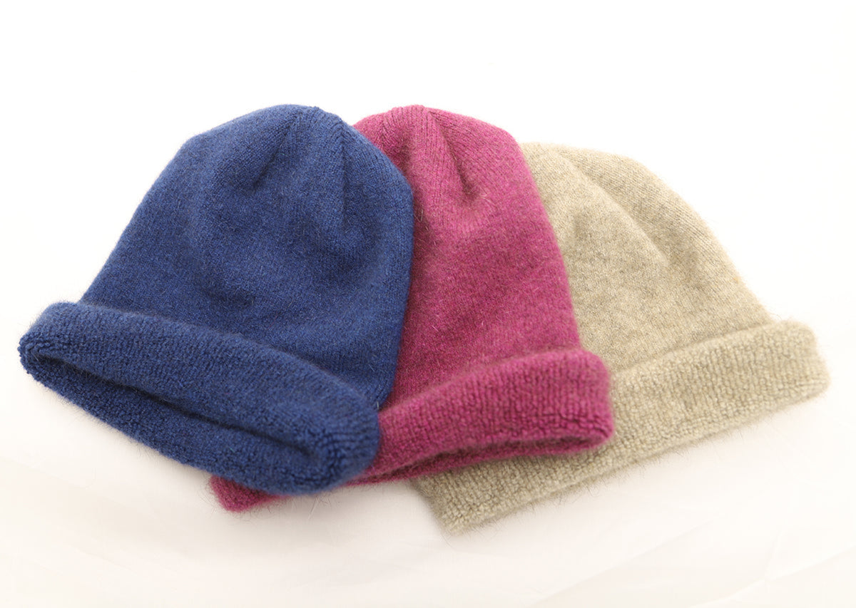 possum merino Three knit hats in blue, pink, and beige on a white background