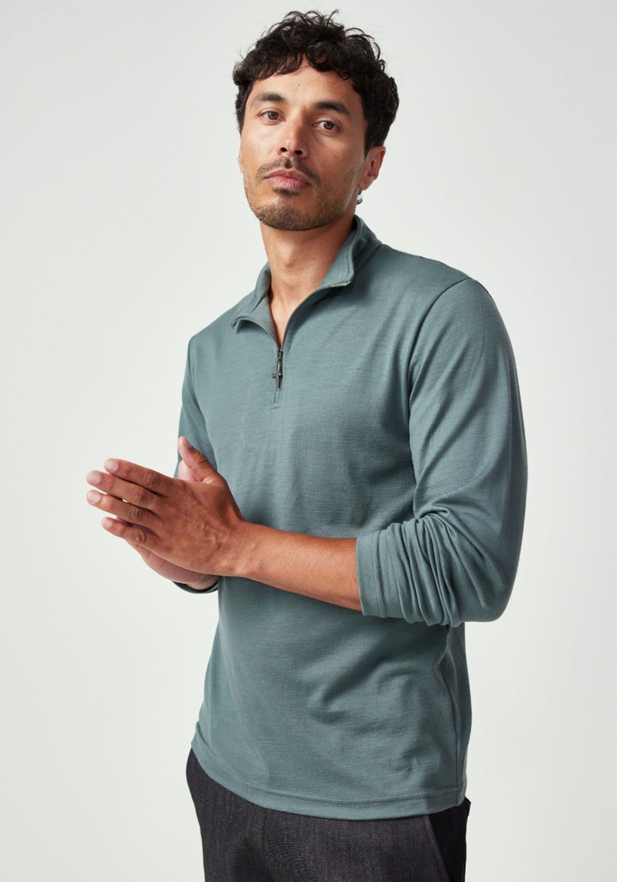 merino Man wearing a teal long-sleeve shirt against a white background