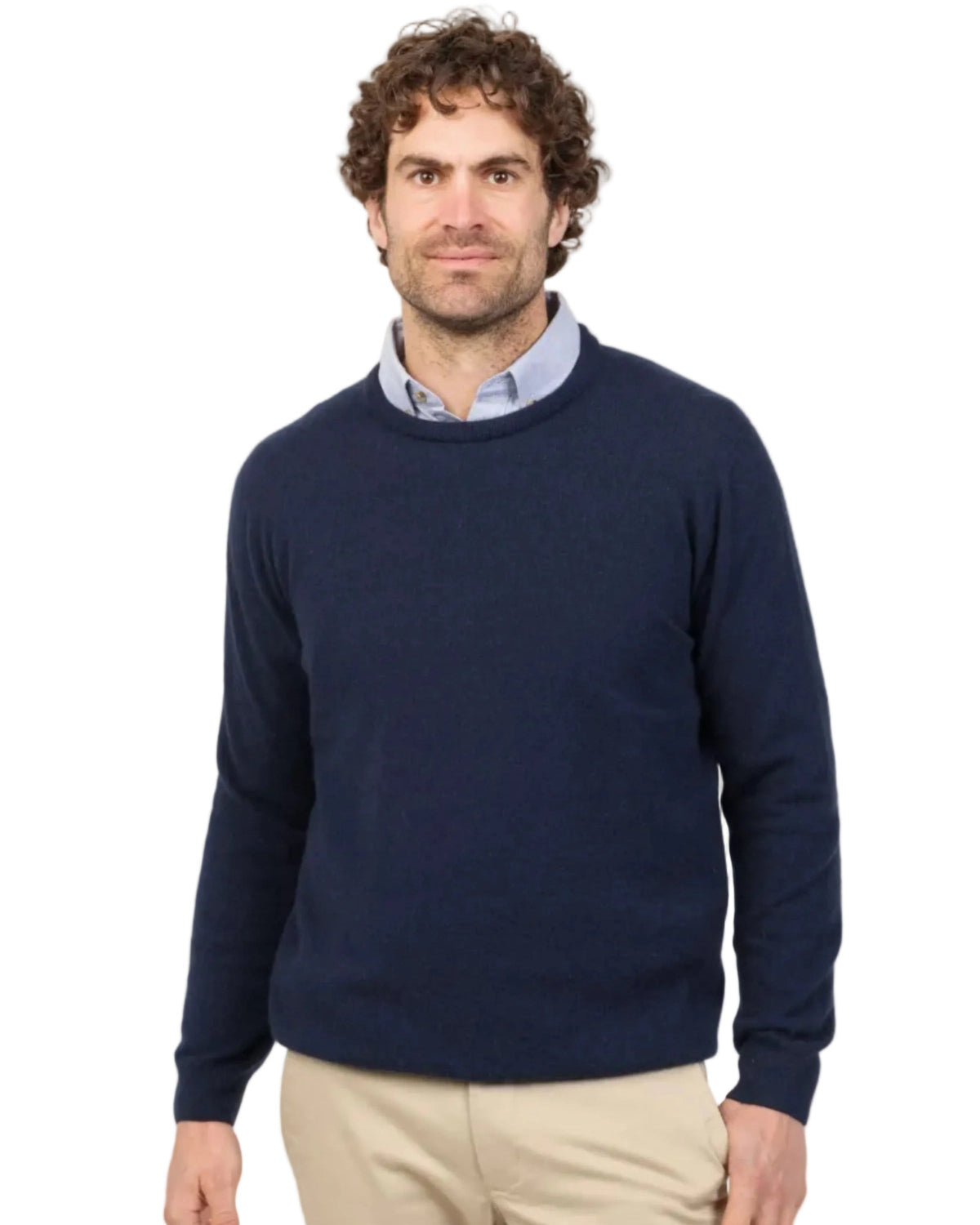 Man wearing a navy Possum Merino sweater and beige pants on a white background