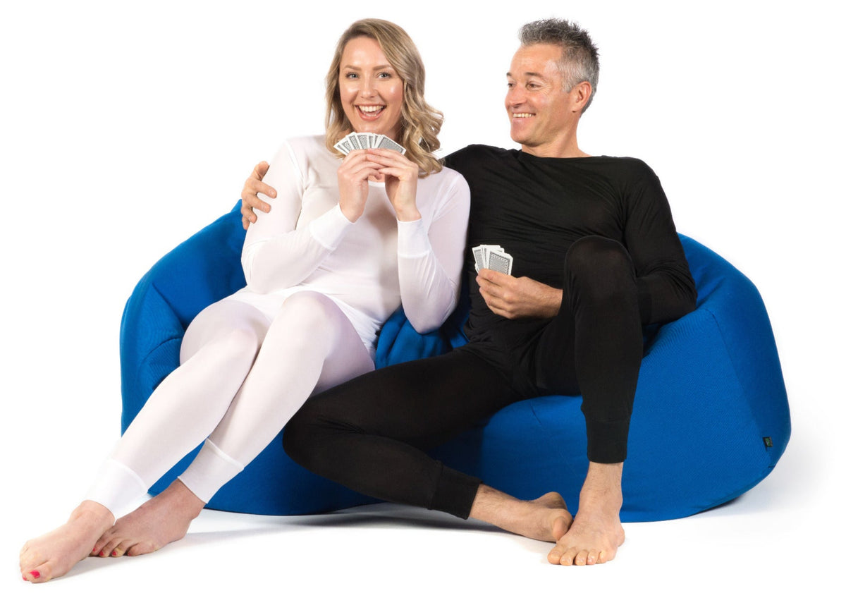 Two people sitting on a blue bean bag silk thermal underwear top and leggings