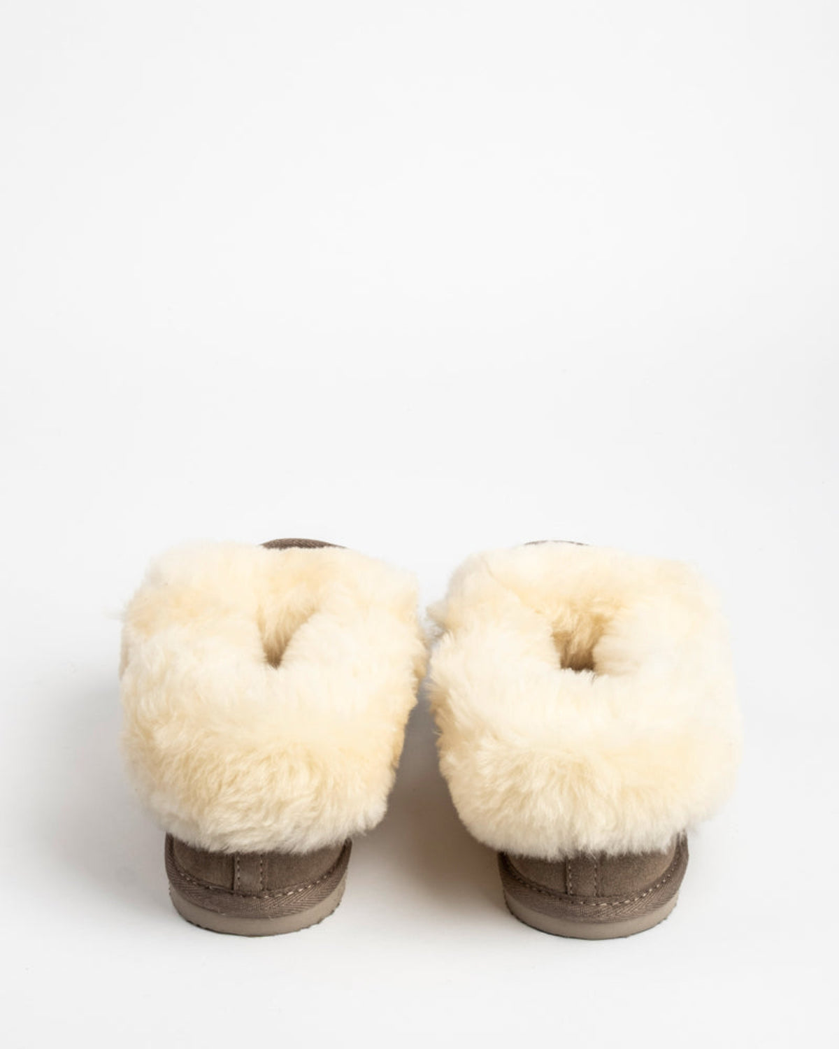 Pair of sheepskin-lined boots on a white background
