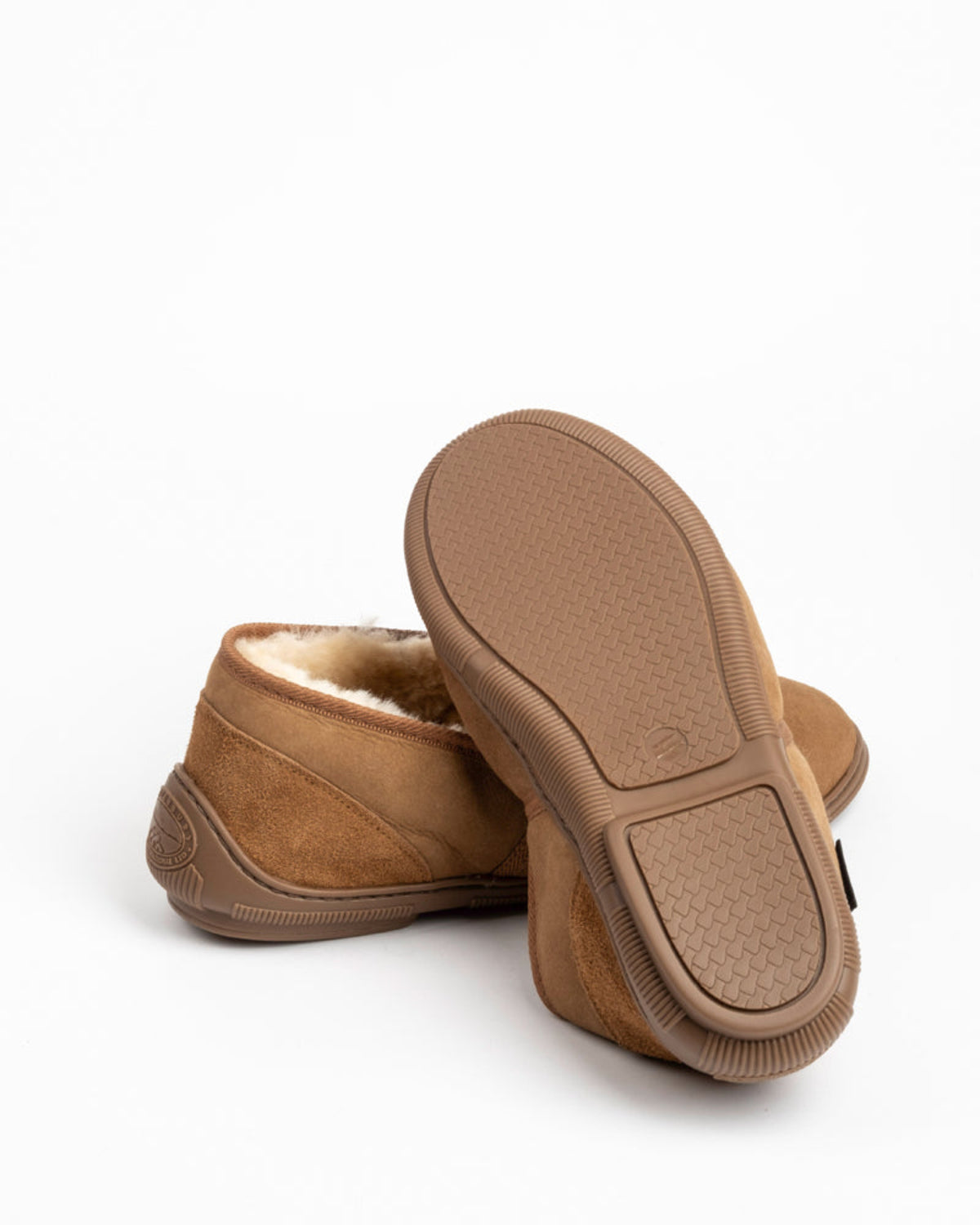 Pair of brown sheepskin slippers on a white background