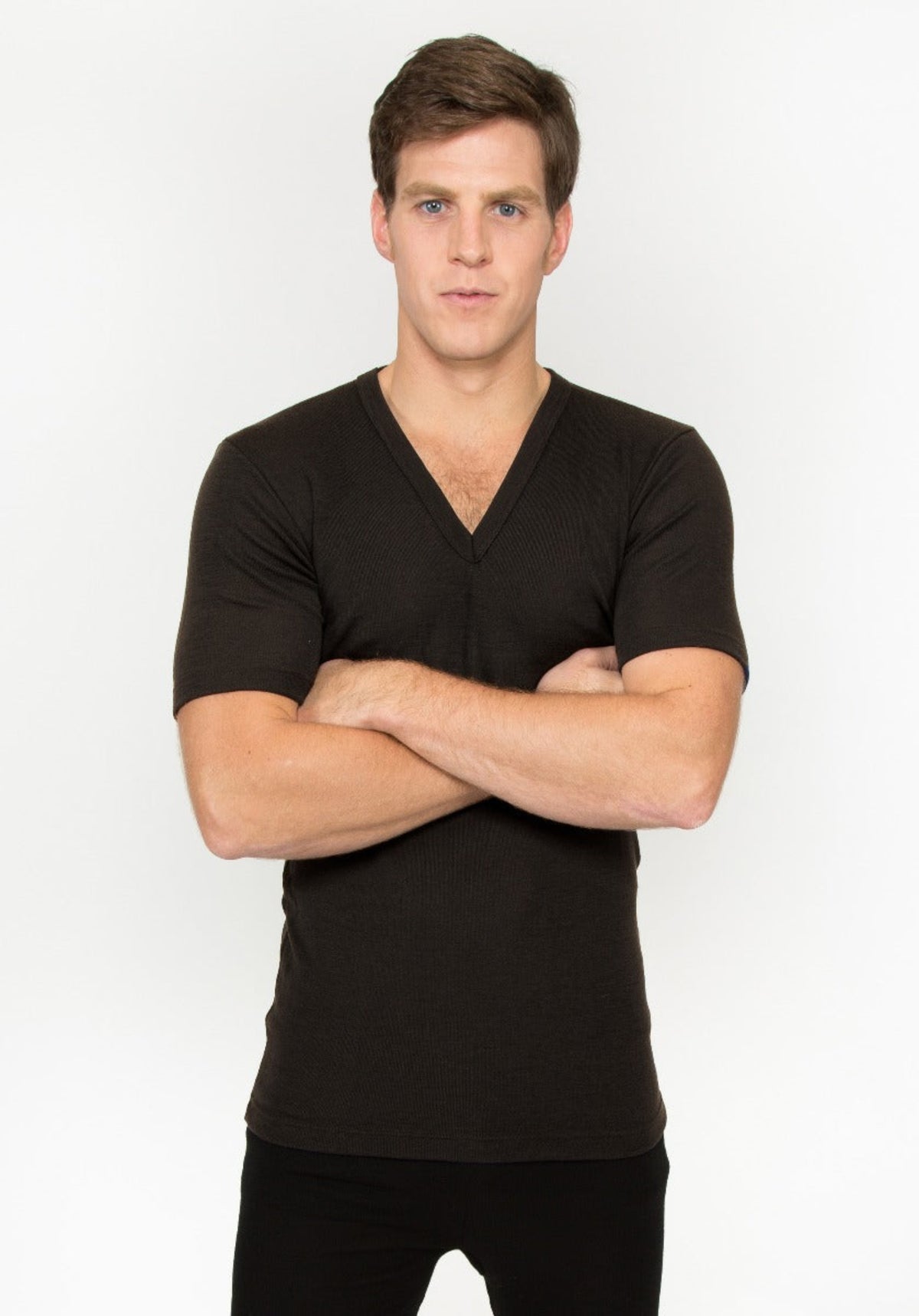 Man wearing a merino black V-neck shirt against a white background